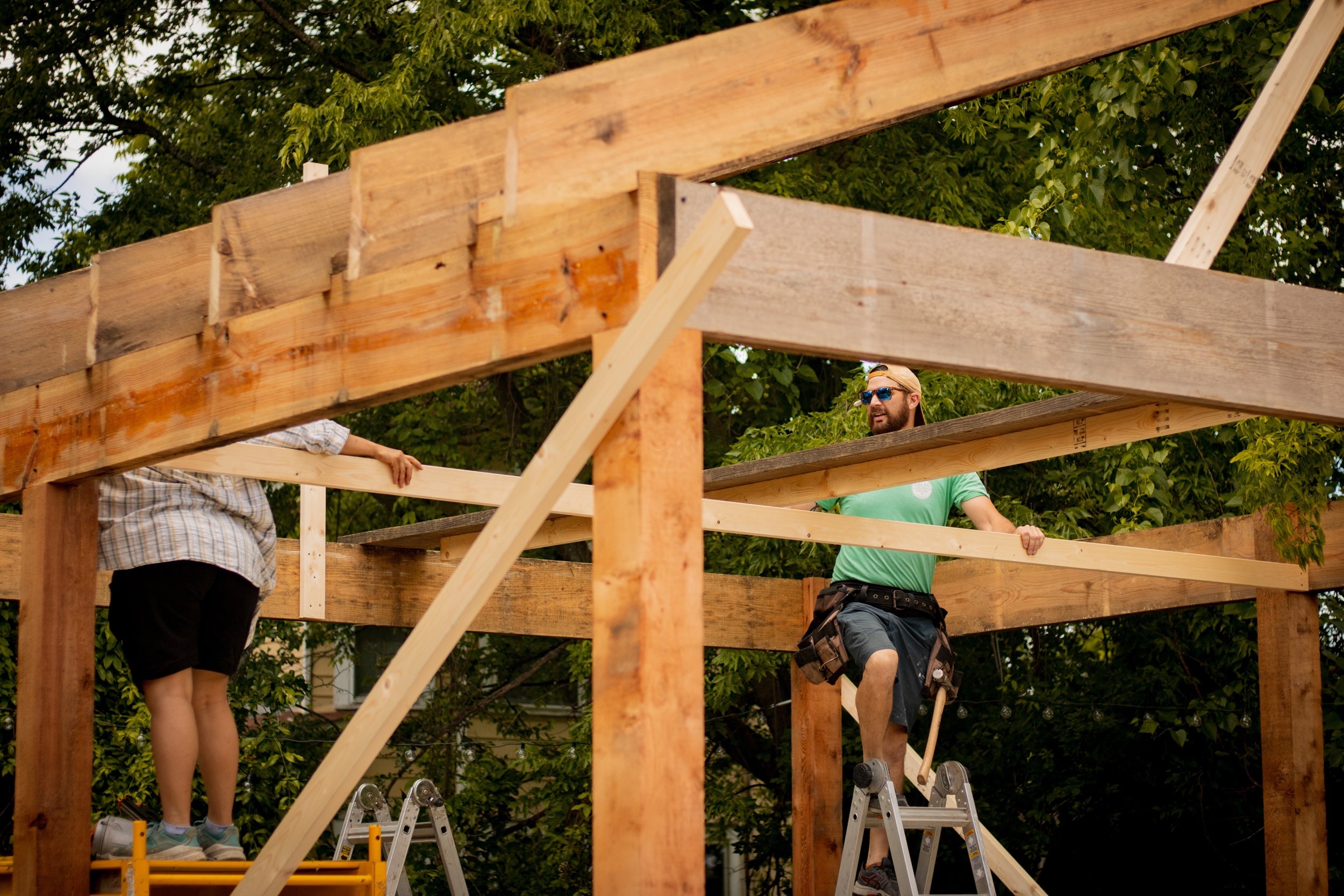 Two people build a house frame on a construction site