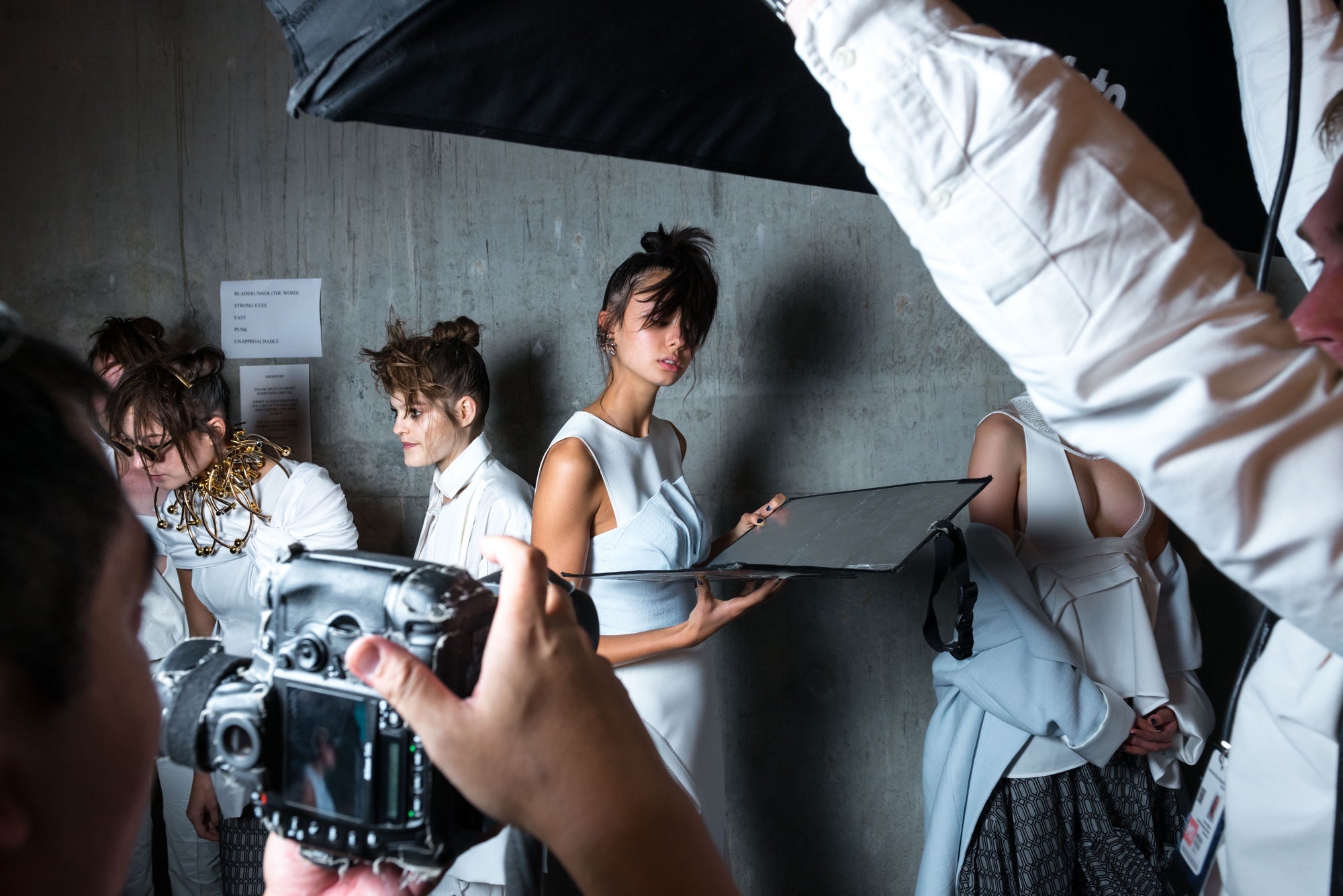 Models prepare for a runway show backstage