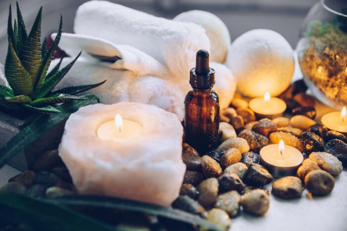 Spa products arranged around plants, stones, and a lit candle