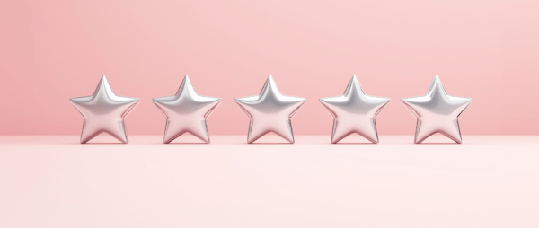 Silver star shaped balloons on a light pink background: customer experience design.