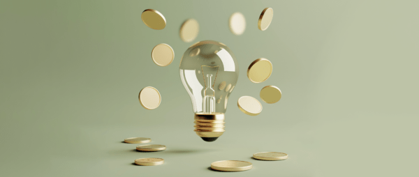 A light bulb is surrounded by falling coins, representing the concept of a million-dollar business idea.