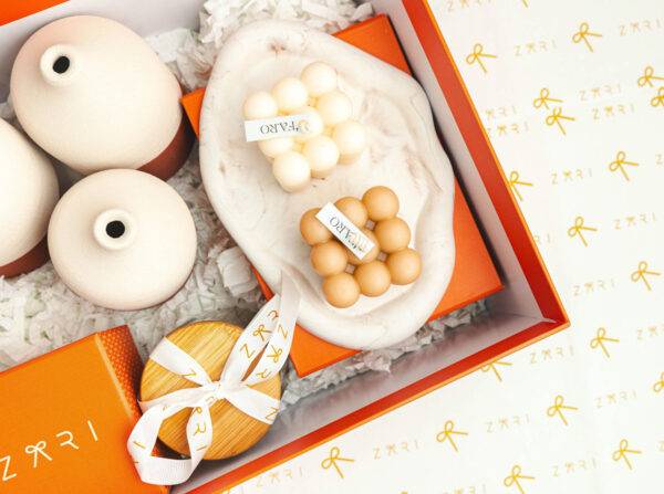 Curated gift box with decorative items and a branded ribbon