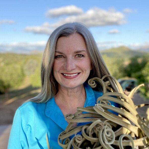 Founder of Partly Sunny Projects holding a plant