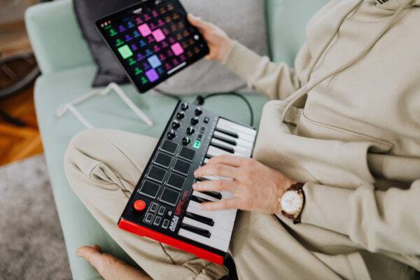 Person playing a mini keyboard connected to a tablet