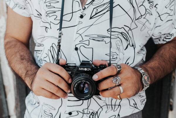 Close-up of a person holding a vintage Minolta camera.