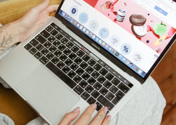 Close-up of hands on a MacBook with a website open