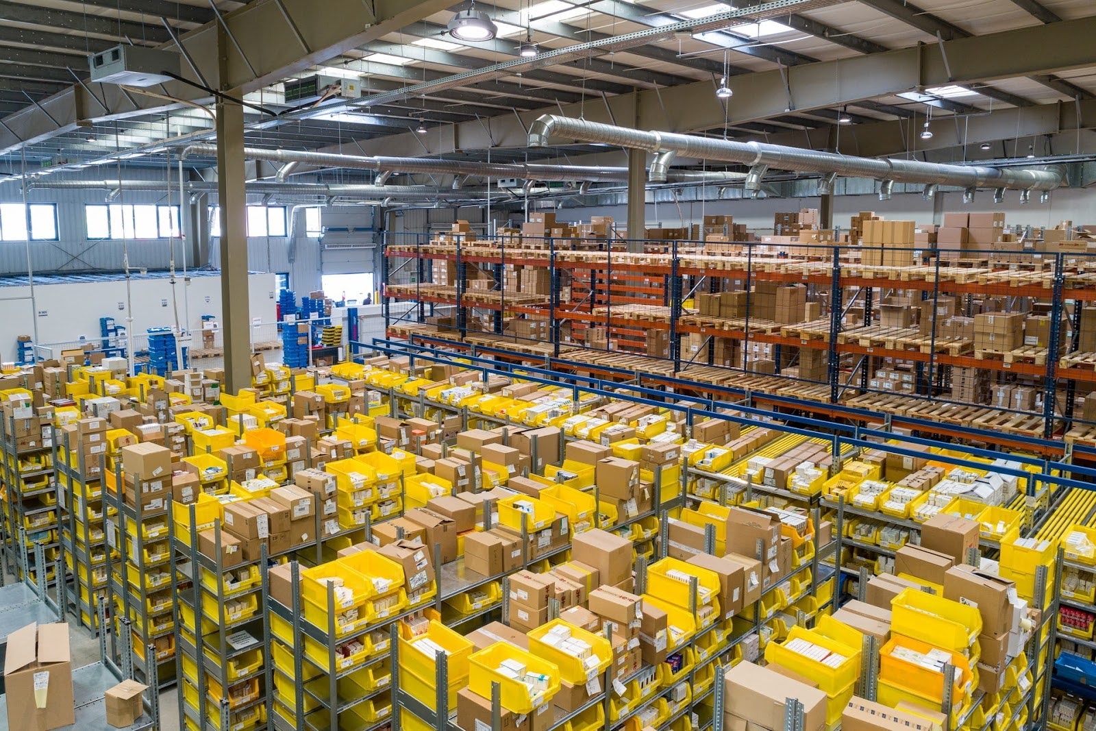 Warehouse full of shelving and boxes piled on top of each other.