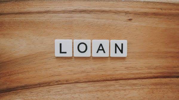 Loan spelled in Scrabble letters on a wood table.